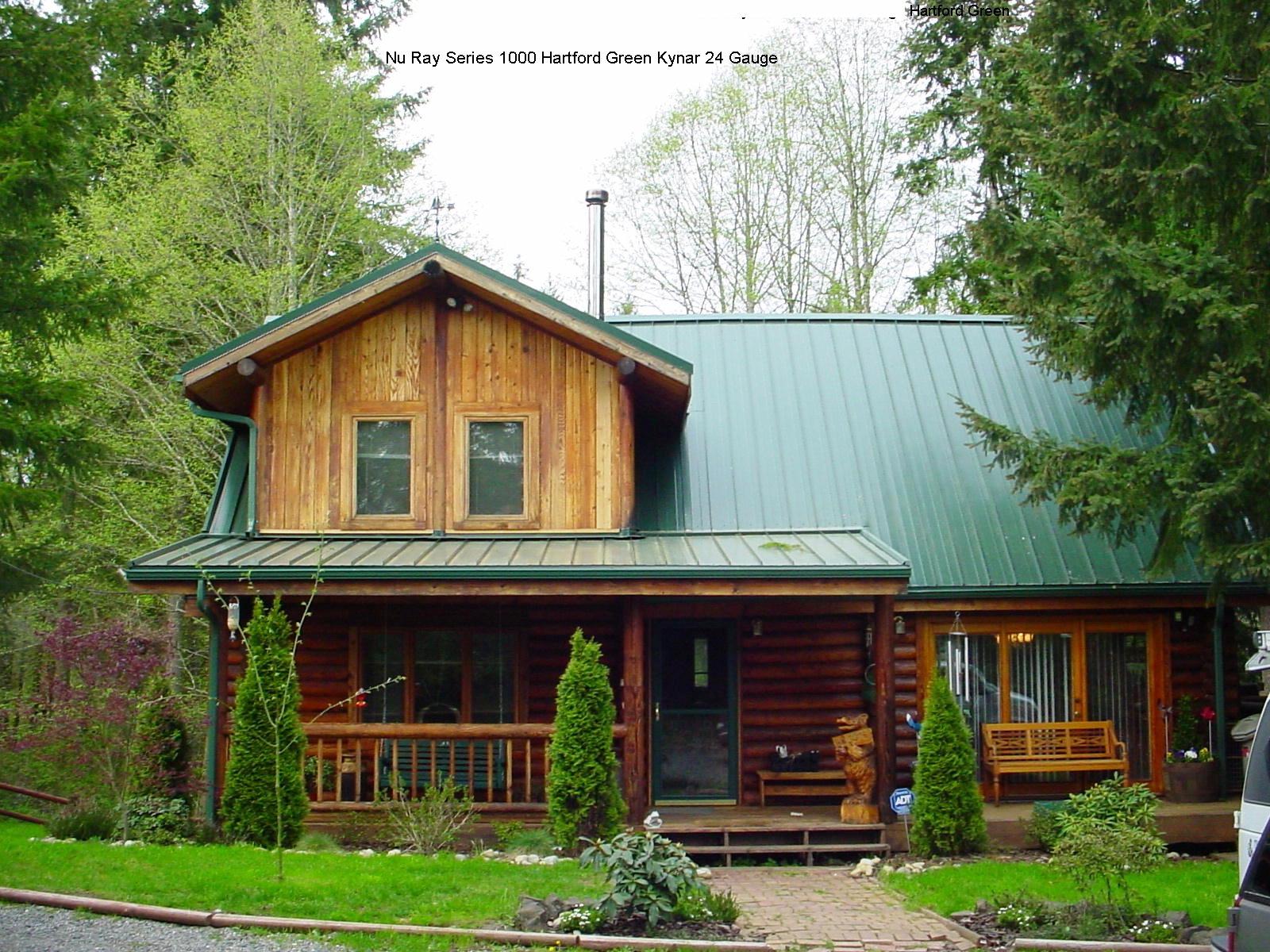 Green standing seam metal roof on a custom log cabin in the Pacific Northwest