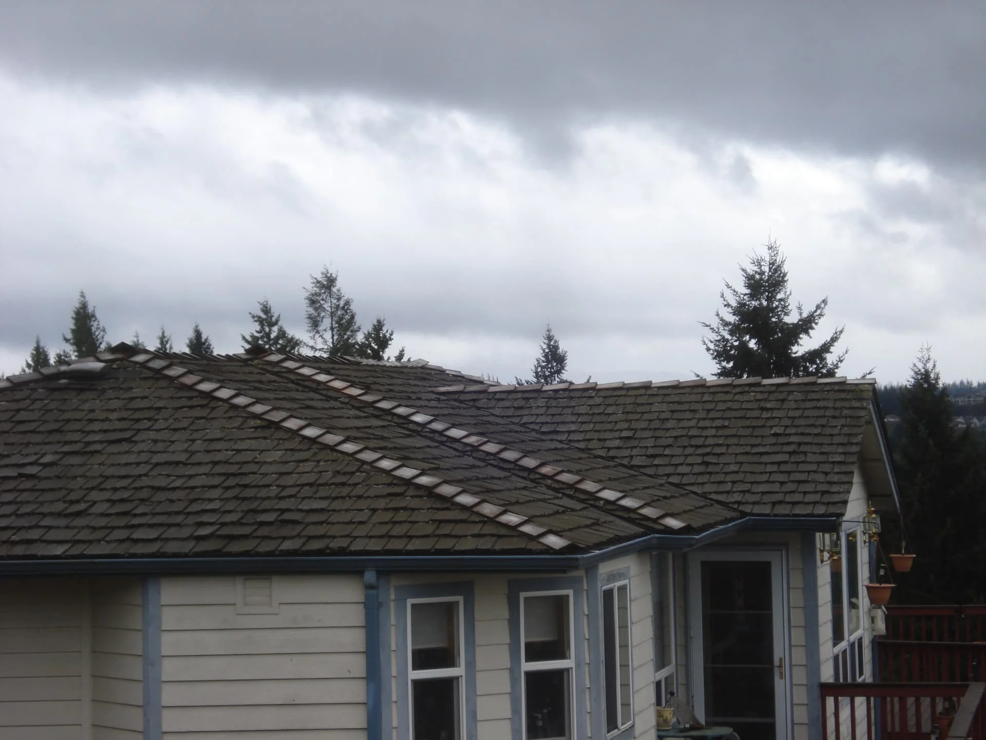 Failing cedar shake roof with lifted shingles before re-roof in Pierce County, WA