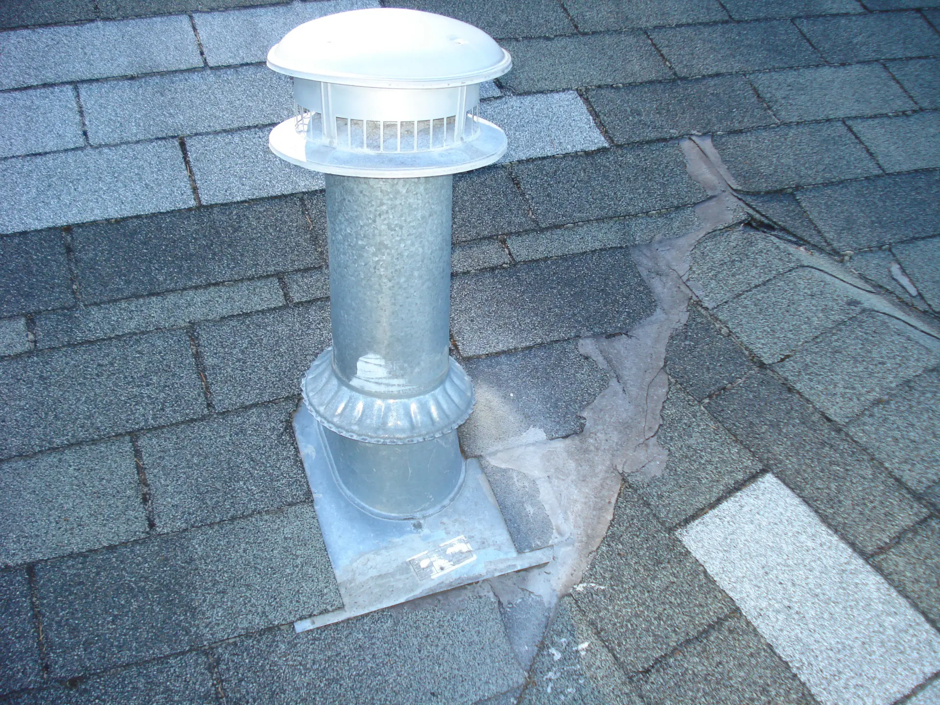 Leaking roof vent with failed tar patch before repair in Tacoma, WA