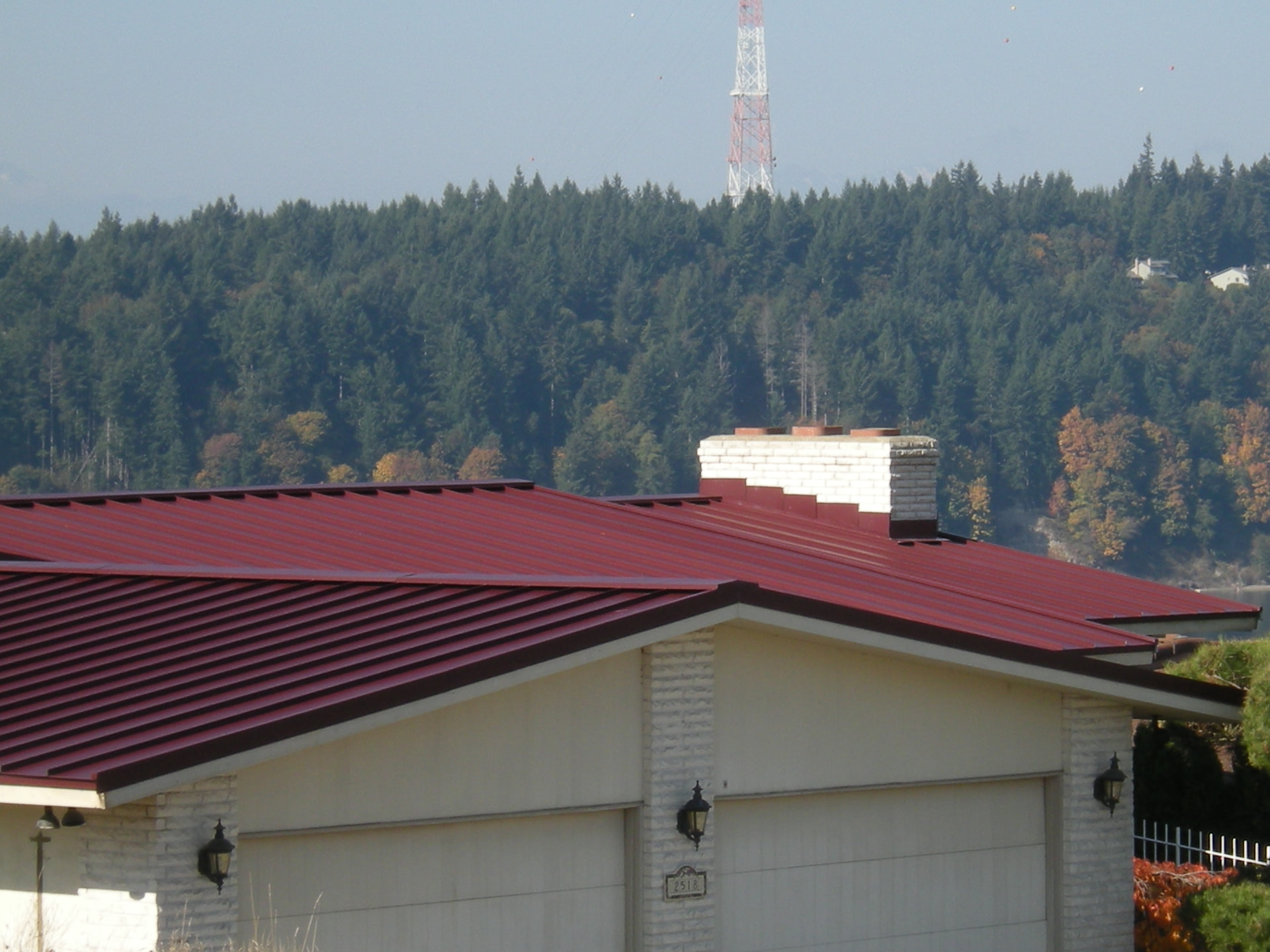 Burgundy standing seam metal roof replacement on a Tacoma rambler with Puget Sound views