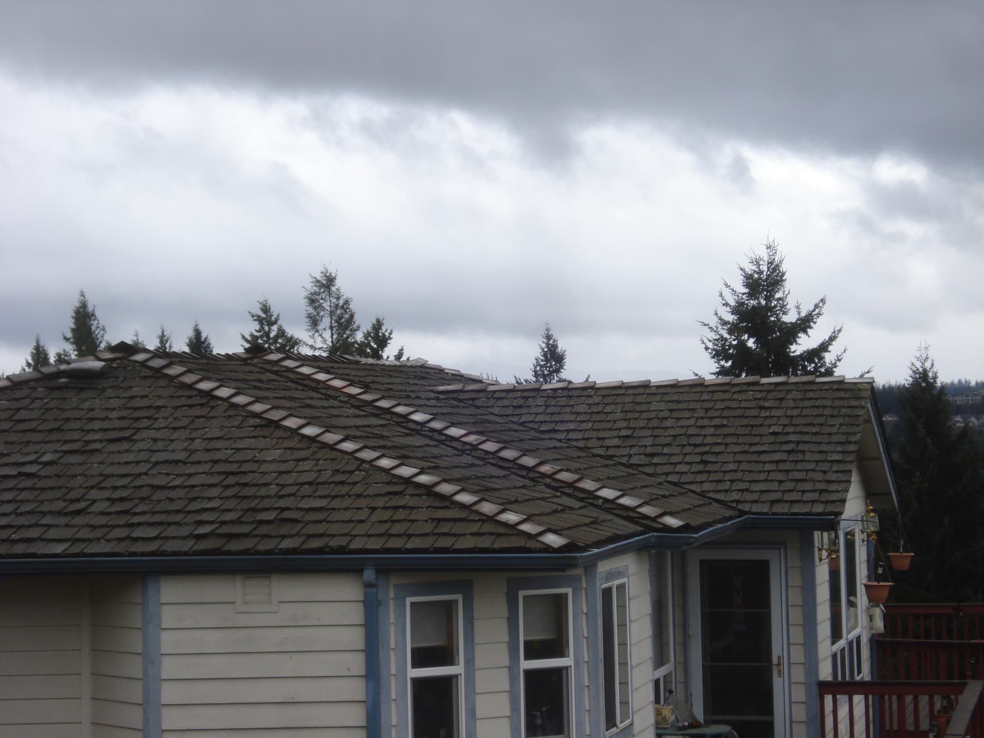 Failing cedar shake roof with lifted shingles before re-roof in Pierce County, WA