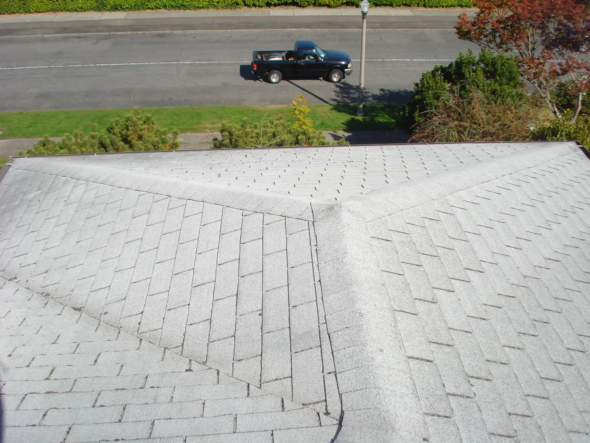 Worn, faded asphalt shingle roof before replacement in Tacoma, WA