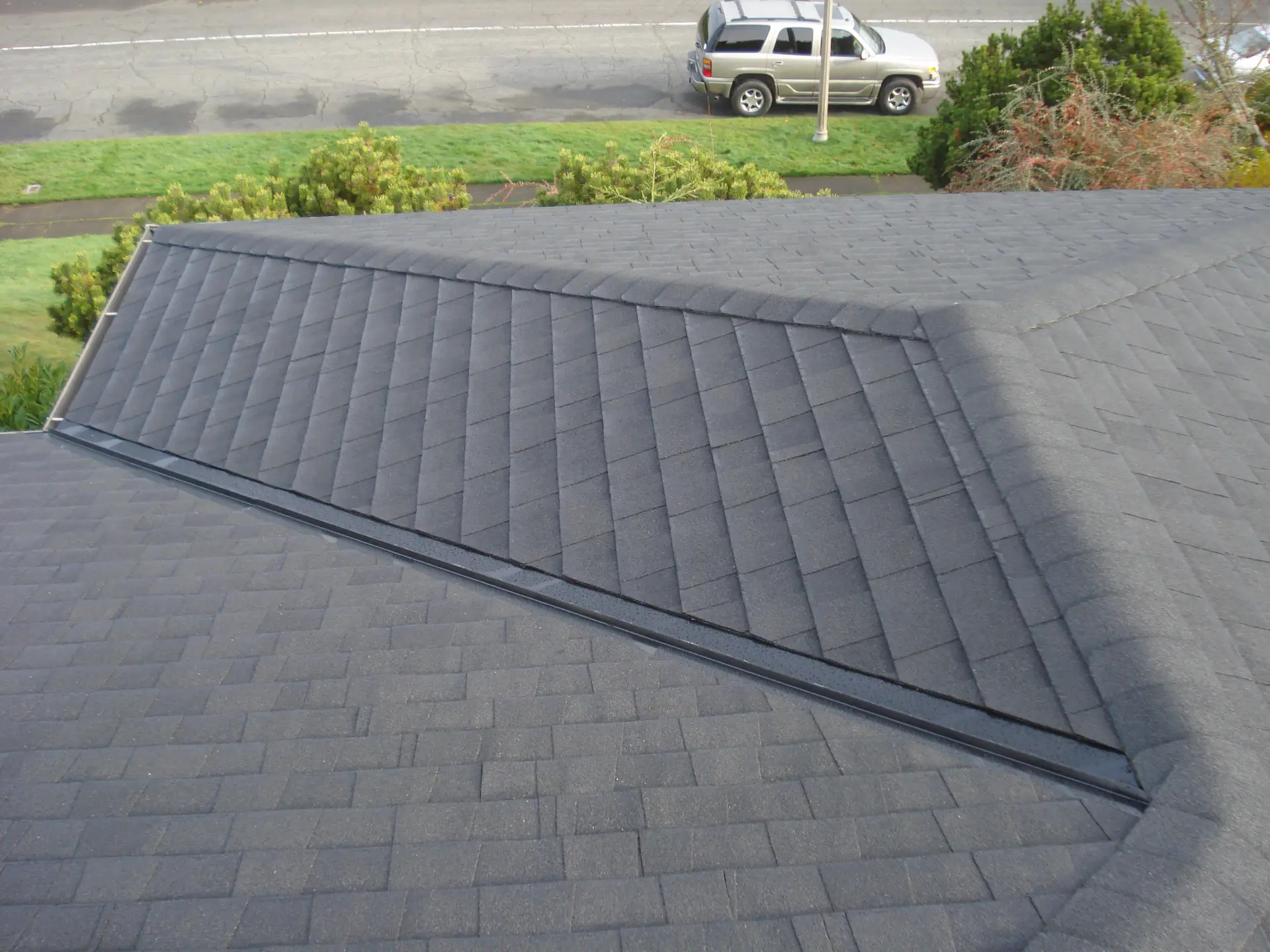 New charcoal architectural asphalt shingle roof with clean hip and ridge lines
