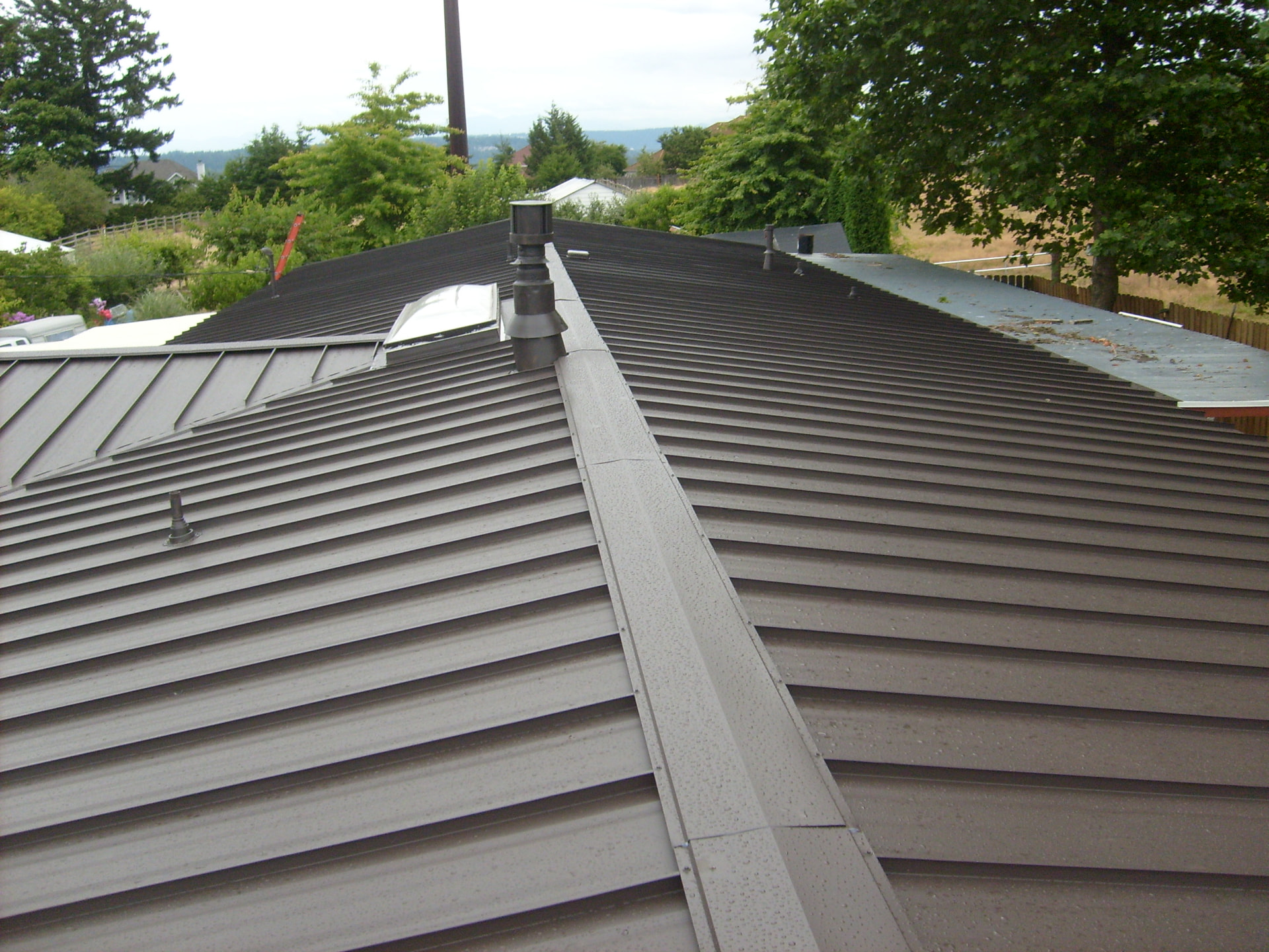 Close-up of a new standing seam metal roof ridge and vents in Tacoma