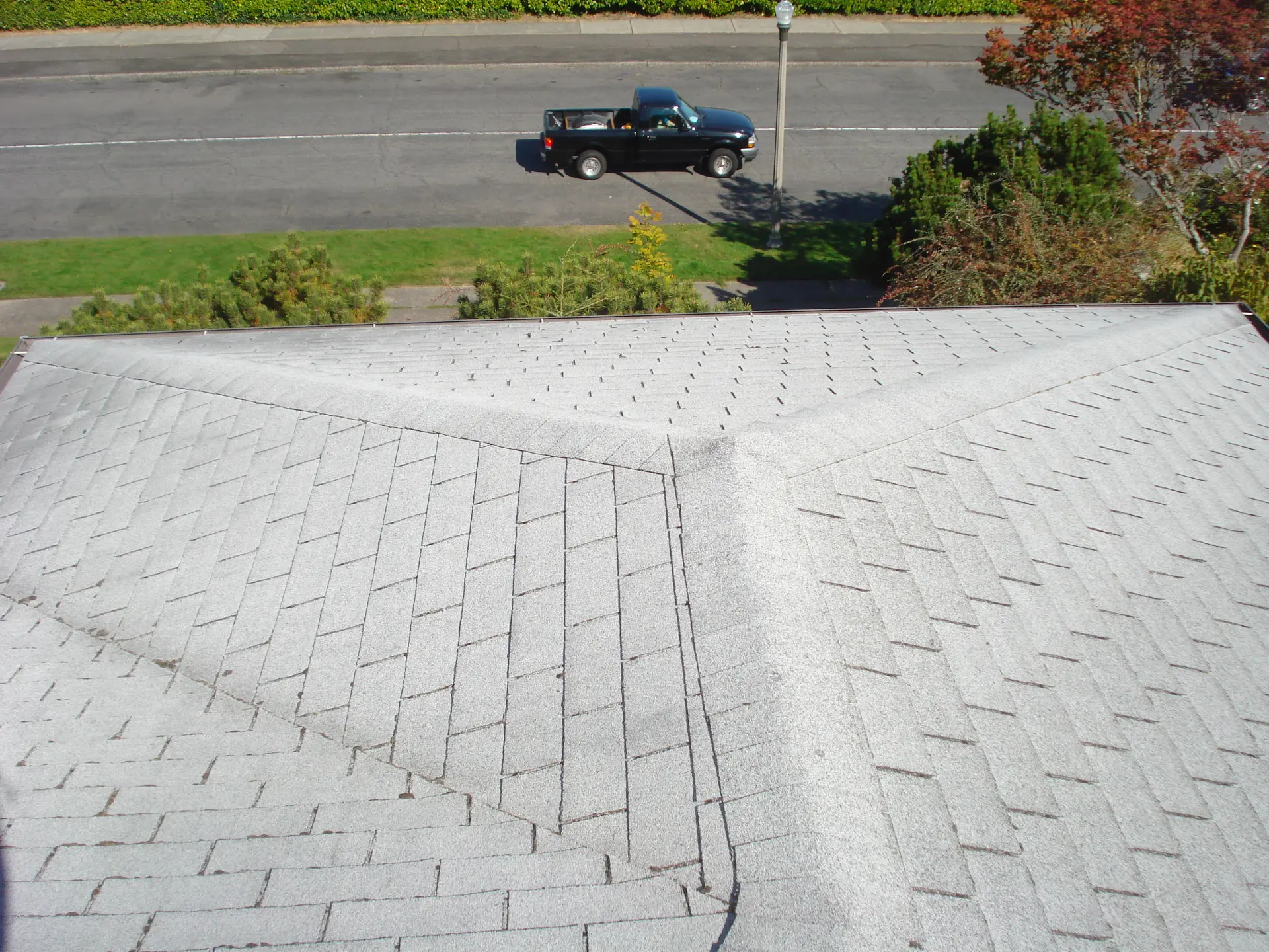 Worn, faded asphalt shingle roof before replacement in Tacoma, WA
